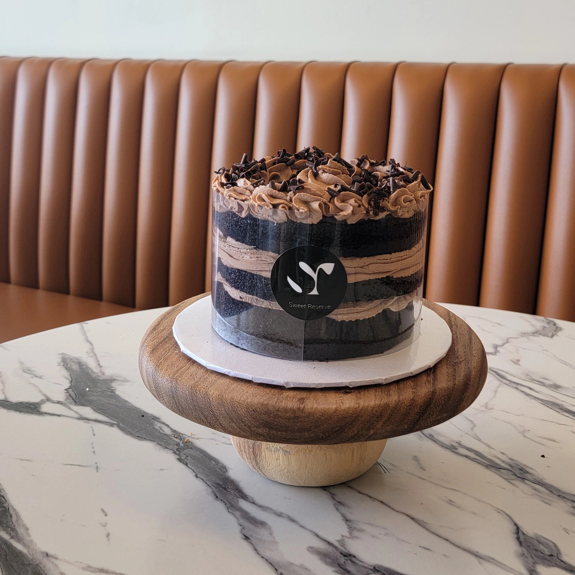 Chocolate Mousse Cake topped with mousse swirls, ganache, and chocolate curls