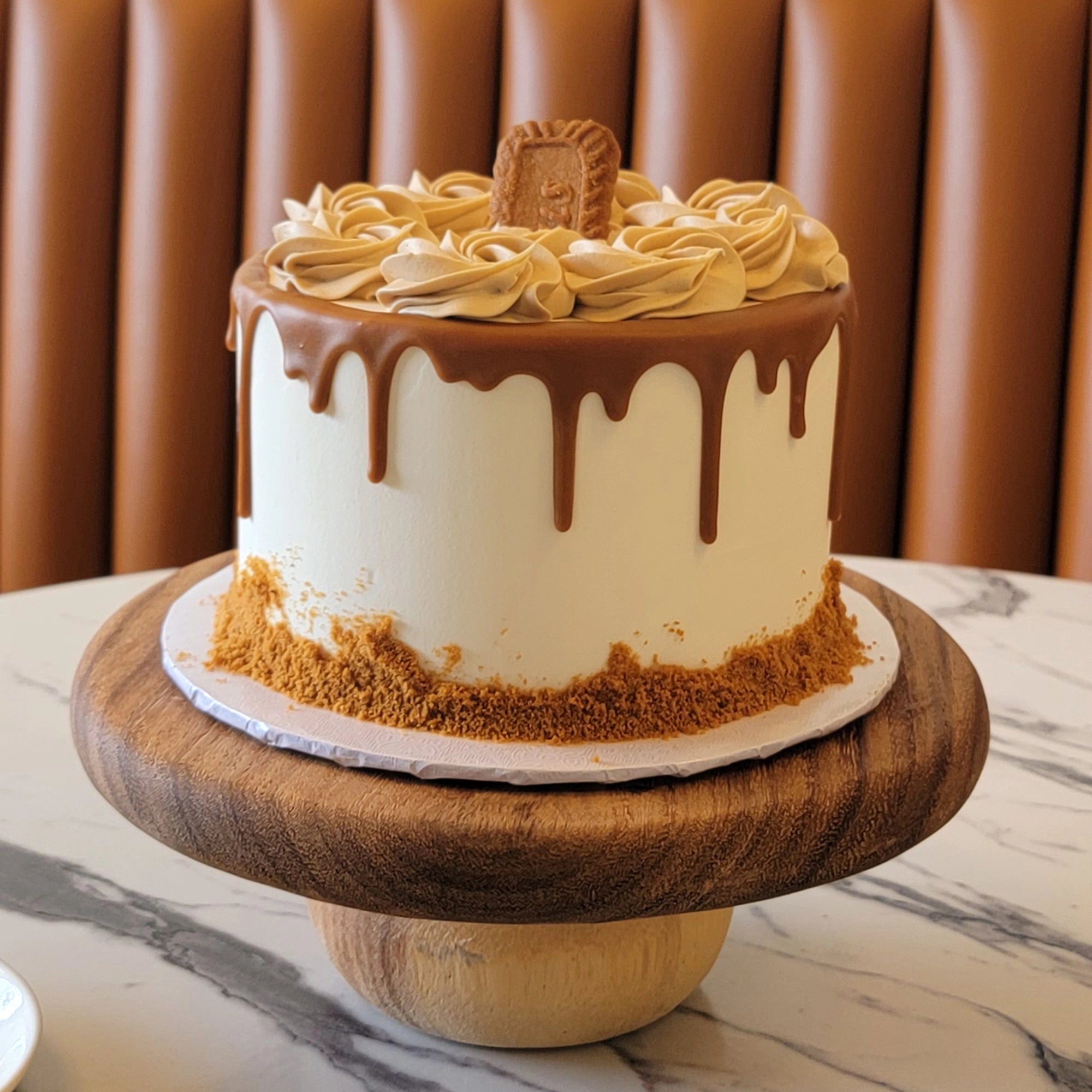 Cookie Butter Cake with white buttercream, cookie butter frosting swirls, and a Lotus cookie on top