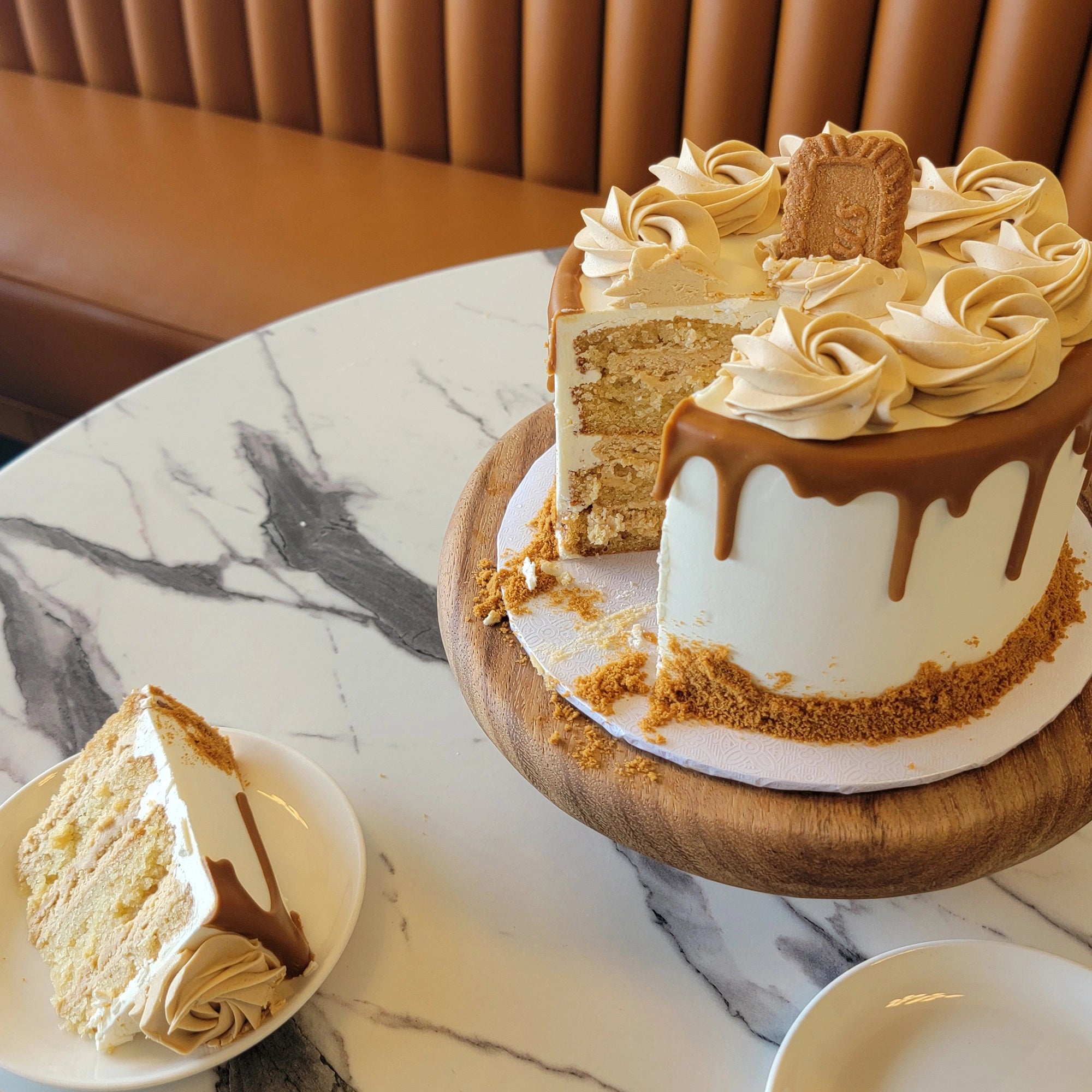 Cookie Butter Cake with white buttercream, cookie butter frosting swirls, and a Lotus cookie on top