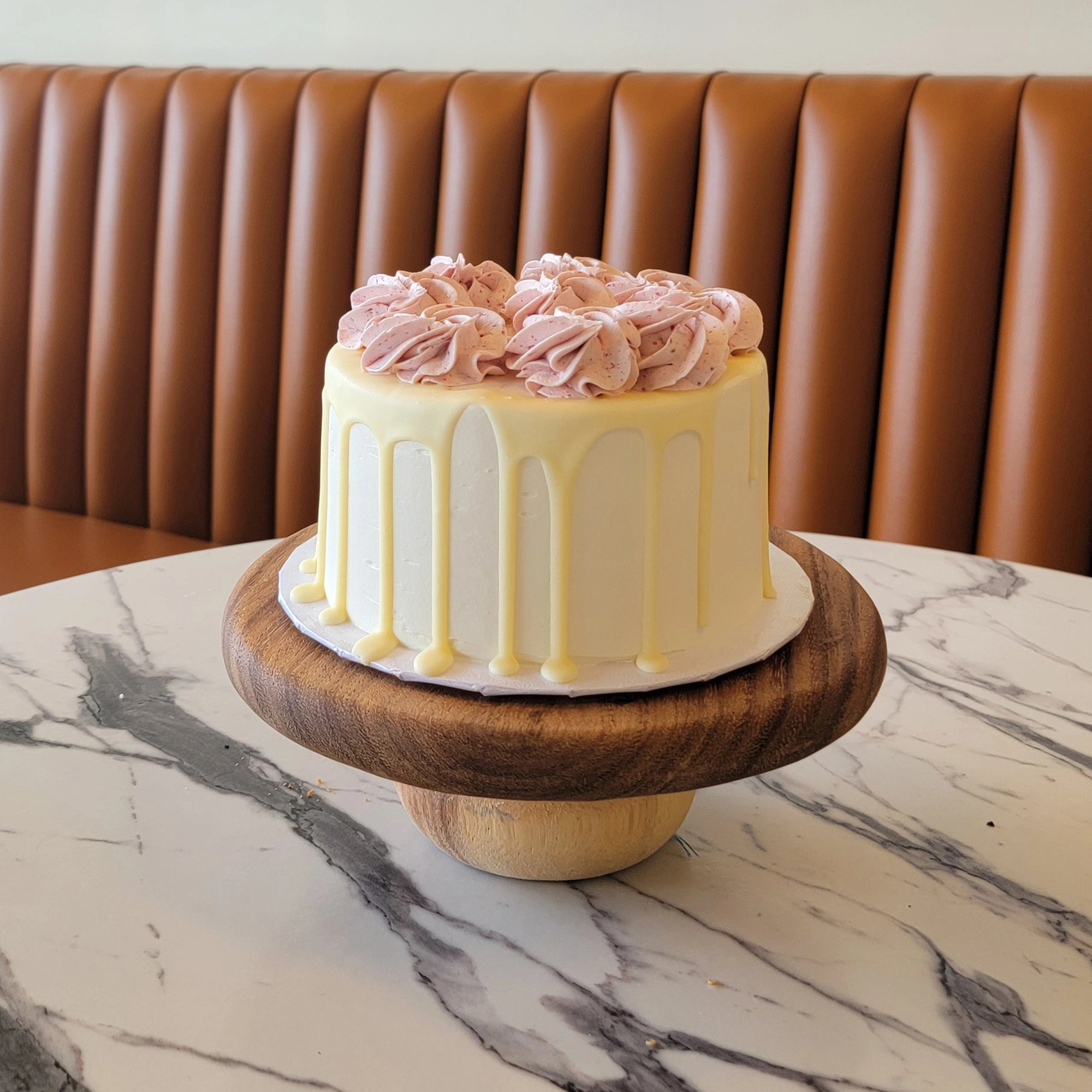White Chocolate Raspberry Cake with raspberry frosting swirls and white chocolate ganache drip